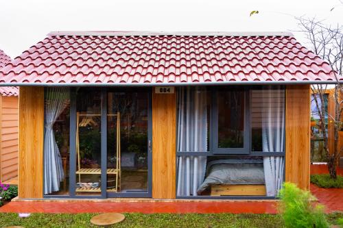 mały dom z czerwonym dachem w obiekcie Hoa Cusc Homestay Măng Đen w mieście Kon Von Kla