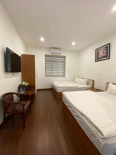 a hotel room with two beds and a table and a desk at Yên Tử Boutique Hotel in Yên Dương