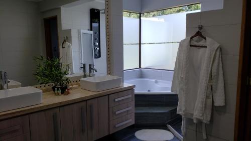 ein Badezimmer mit einer Badewanne, 2 Waschbecken und einer Badewanne in der Unterkunft Borde Luz Hotel Boutique in Pucón