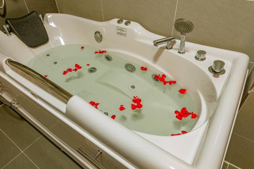 a white bath tub with red flowers in it at ZEN RIVERSIDE HOTEL & RESIDENCES in Hai Phong