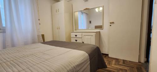 Depto de 2 ambientes zona Guemes (2) في مار ديل بلاتا: غرفة نوم بسرير ومرآة كبيرة