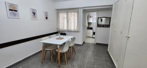Depto de 2 ambientes zona Guemes (2) في مار ديل بلاتا: طاولة بيضاء صغيرة وكراسي في غرفة