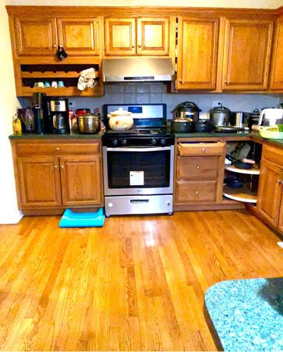 a kitchen with a stove and a wooden floor at B4 A private room in Naperville downtown with desk and Wi-Fi near everything in Naperville