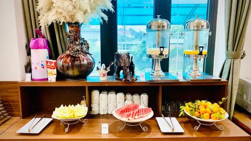 a shelf with bowls of fruit on a table at Trang An International Hotel in Ninh Binh
