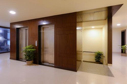 an office lobby with a elevator and two potted plants at Clover - A Rivido Hotel Jigani in Bengaluru
