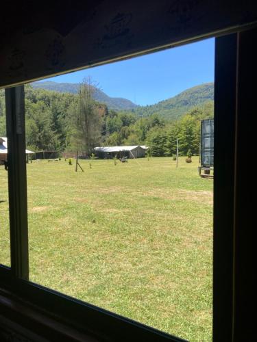 a view of a field from a window at Los arrayanes de huife pucon in Termas De Huife