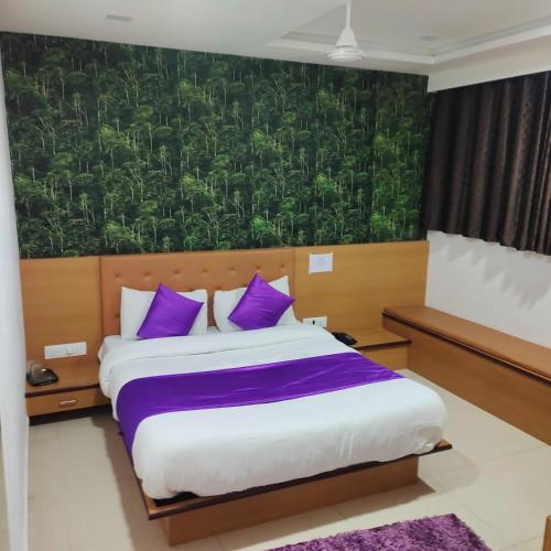 een slaapkamer met een groot bed met paarse kussens bij HOTEL GLOBLE in Vadodara