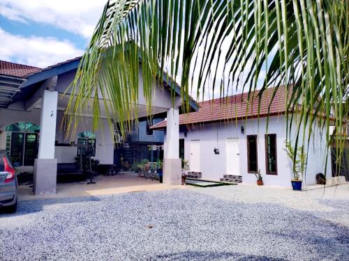 a house with a palm tree in front of it at Roomstay Kak Ton in Kuala Terengganu