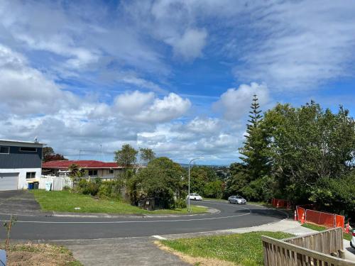 a winding road with a car driving down a street at Totara Vale, Free Coffee, parking and wifi, near Glenfield Mall and highway 18,1 in Auckland