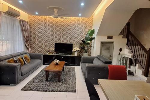 uma sala de estar com sofás e uma mesa de centro em HANI MAWADDAH HOMESTAY SEKSYEN 7 SHAH ALAM em Shah Alam