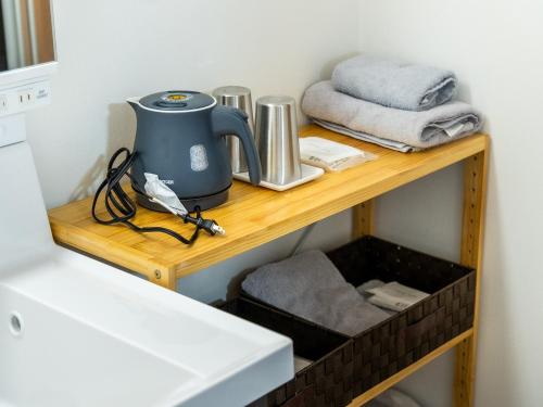 einen Wasserkocher auf einem Holzregal in einem Zimmer in der Unterkunft Shima no Hotel in Sado