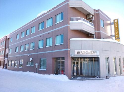 a large building with snow in front of it at Hotel Trend Asahikawa in Asahikawa