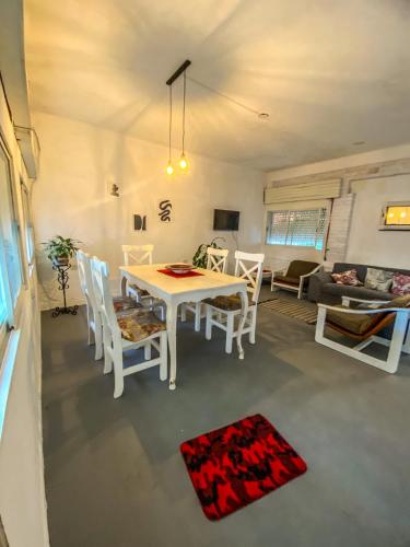 uma sala de jantar e sala de estar com mesa e cadeiras em Casa Candiotti em Paraná