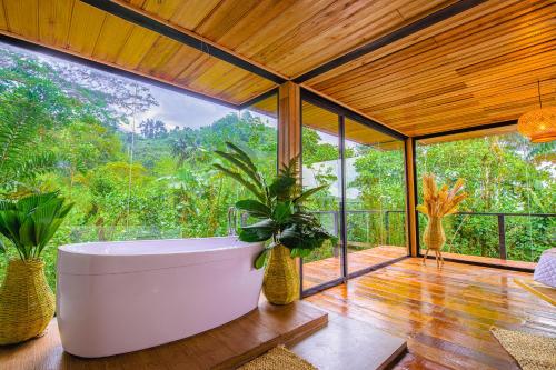 Cedro Amazon Lodge في Mera: حوض استحمام في غرفة مع نافذة كبيرة