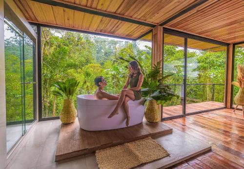 a man and woman sitting in a bath tub on a porch at Cedro Amazon Lodge in Mera