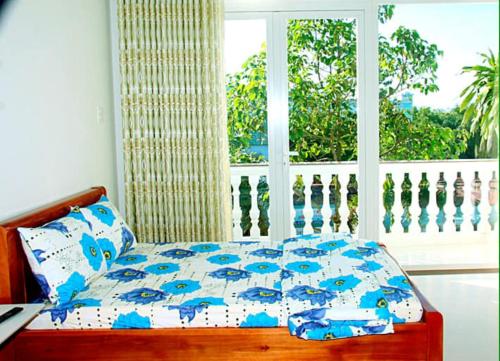 a bed in a bedroom with a large window at Khách sạn Hương Sen Sa Dec in Sa Ðéc
