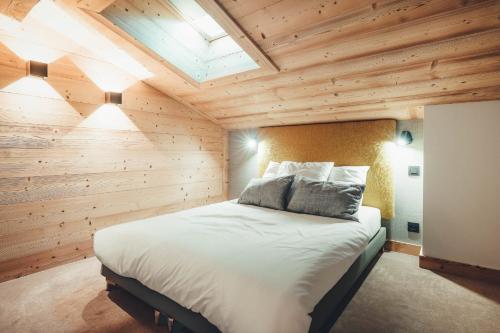 - une chambre avec un grand lit dans un mur en bois dans l'établissement Appartement Keraos - Perfect for a family holiday in Megeve, à Megève