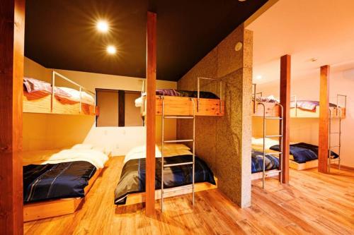 a room with three bunk beds in a room at D plus one doors in Otaru