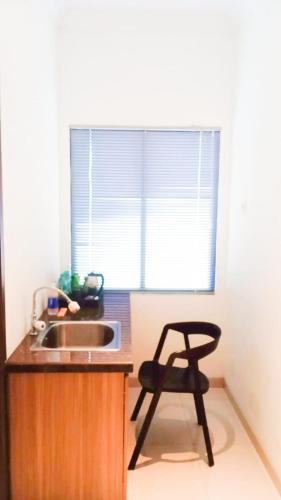 a kitchen with a chair next to a sink at Grand Rohan Jogja in Yogyakarta