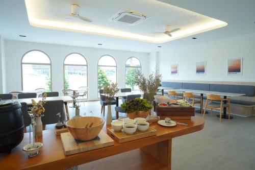 a room with a table with bowls and cups on it at Alto Hotel M in Mae Sot
