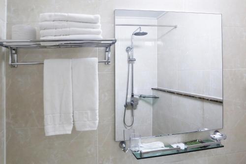 a bathroom with a shower with a mirror and towels at Incheon The Hotel Yeongjong in Incheon