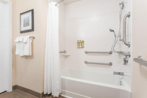 a bathroom with a tub and a shower at Candlewood Suites Eau Claire I-94 by IHG in Eau Claire