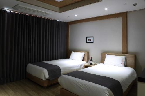 a hotel room with two beds and a window at Incheon The Hotel Yeongjong in Incheon