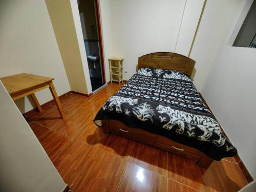 Bett in einem Zimmer mit Holzboden in der Unterkunft Amplio Departamento en 2do piso in Cajamarca