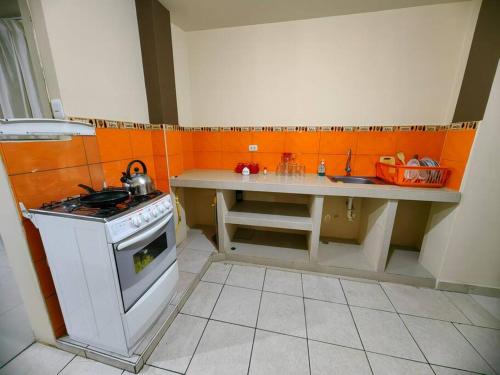 eine kleine Küche mit Herd und Spüle in der Unterkunft Amplio Departamento en 2do piso in Cajamarca