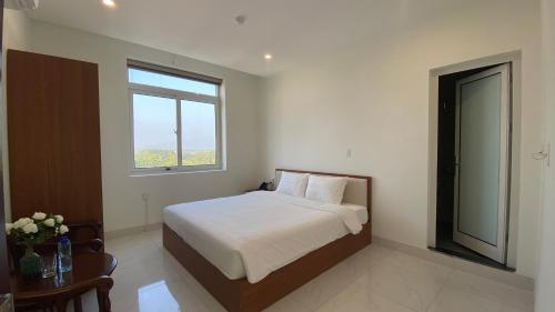1 dormitorio con cama, ventana y mesa en Yên Tử Boutique Hotel, 