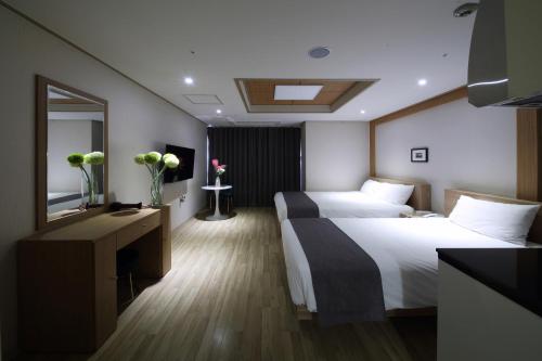 a hotel room with two beds and a mirror at Incheon The Hotel Yeongjong in Incheon