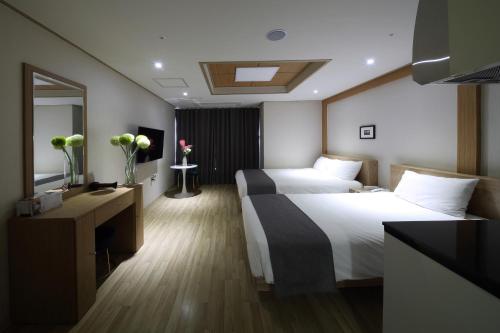 a hotel room with two beds and a mirror at Incheon The Hotel Yeongjong in Incheon