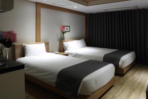 a hotel room with two beds and flowers on the wall at Incheon The Hotel Yeongjong in Incheon