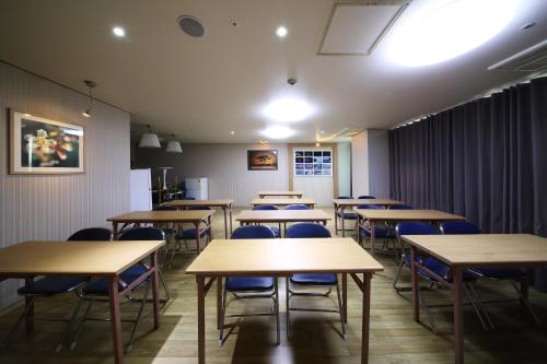 a classroom with rows of tables and blue chairs at Incheon The Hotel Yeongjong in Incheon