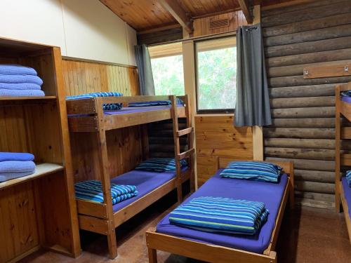 um quarto com beliches num chalé de madeira em Iluka Retreat Glamping Village em Red Hill South