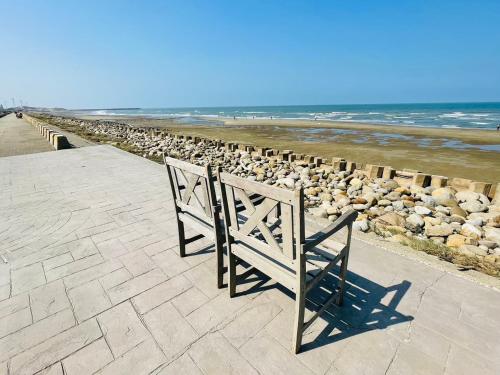 a pair of benches sitting on a pier near the beach at N-square Hostel 任意宿背包客棧 in Yuanli