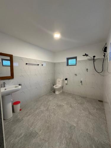 an empty bathroom with a toilet and a sink at Villa 95 Hiriketiya in Dickwella