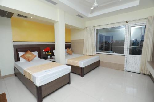 una camera con due letti e una finestra di HOTEL PALACE a Madurai