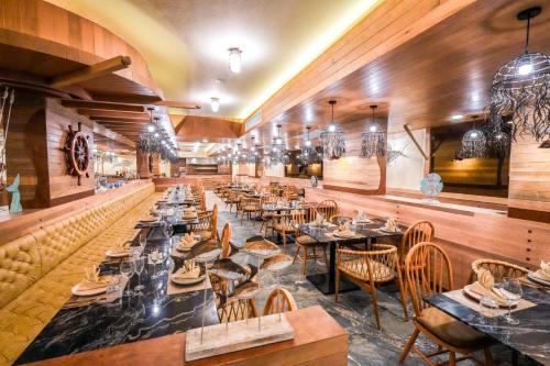 a restaurant with tables and chairs in a room at The Marin Phuket Kamala Beach in Kamala Beach