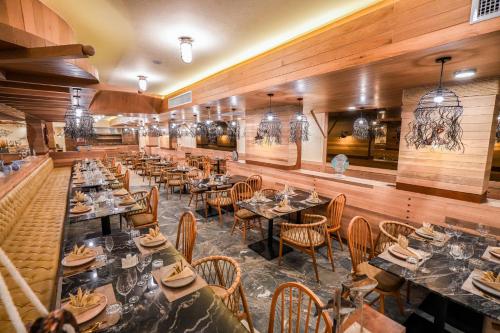 a restaurant with wooden walls and tables and chairs at The Marin Phuket Kamala Beach in Kamala Beach