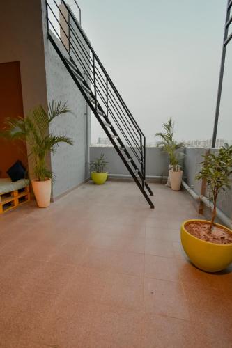 a balcony with potted plants and a staircase at HomeSlice Whitefield in Bengaluru