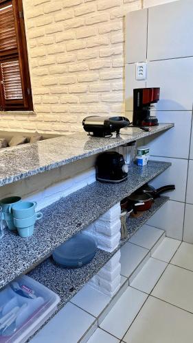 a counter in a kitchen with plates on it at Suítes Bosque de Flecheiras in Flecheiras
