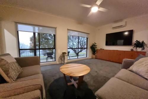 a living room with a couch and a table at Perfect Country Home in Tawonga