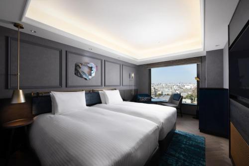 a hotel room with a large bed and a large window at Mercure Tokyo Haneda Airport in Tokyo