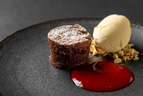 a chocolate dessert and ice cream on a black plate at Mercure Tokyo Haneda Airport in Tokyo