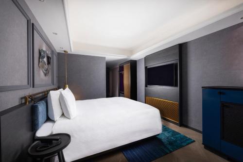 a hotel room with a white bed and a television at Mercure Tokyo Haneda Airport in Tokyo