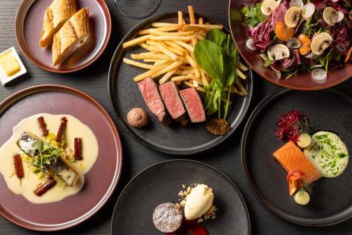 a table topped with plates of food and french fries at Mercure Tokyo Haneda Airport in Tokyo