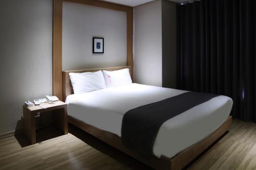 a bedroom with a large bed with a side table at Incheon The Hotel Yeongjong in Incheon
