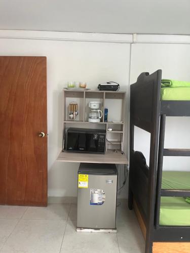 a dorm room with a microwave and a bunk bed at Fuentes House in San Andrés