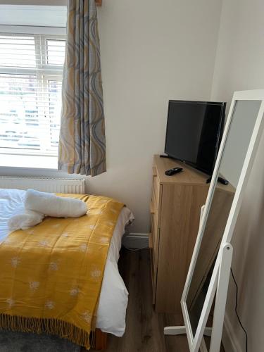 a bedroom with a bed and a tv and a mirror at Comfortable Single Room Wembley Park/Stadium in London